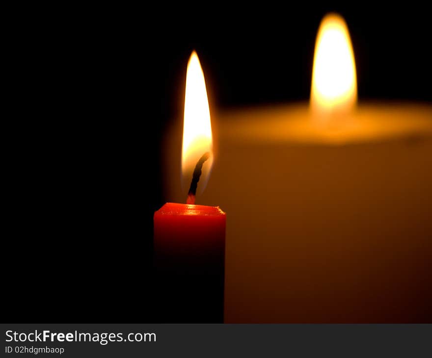 Two candles flaming in the dark