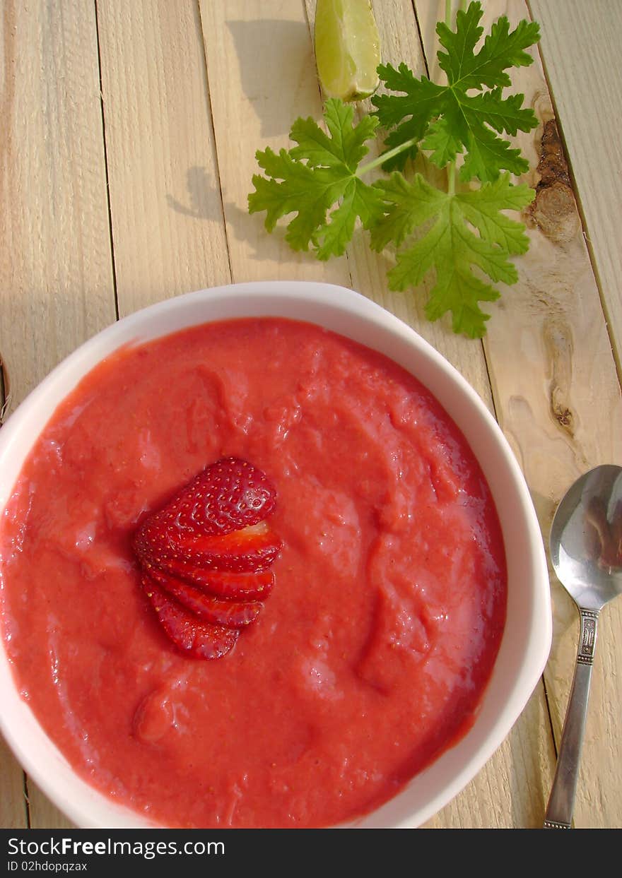 A bowl full of delicious strawberry cream and yoghurt, on rustic wooden table