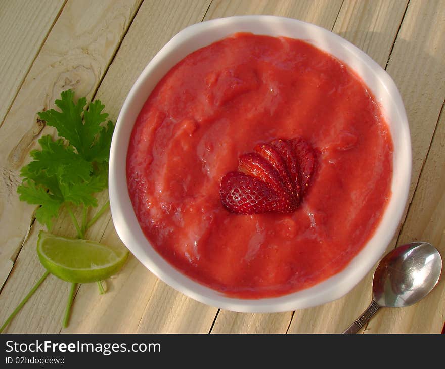 A bowl full of delicious strawberry cream and yoghurt, on rustic wooden table