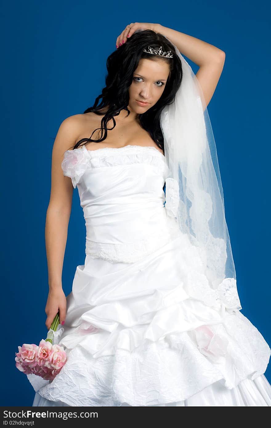 Portrait of beautiful happy bride in a wedding dress on blue background studio shot. Portrait of beautiful happy bride in a wedding dress on blue background studio shot