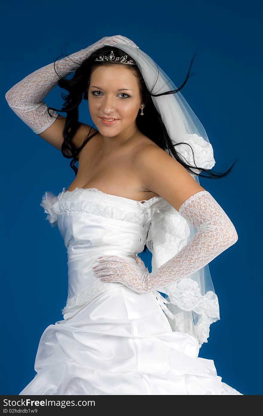 Portrait of beautiful happy bride in a wedding dress on blue background studio shot. Portrait of beautiful happy bride in a wedding dress on blue background studio shot