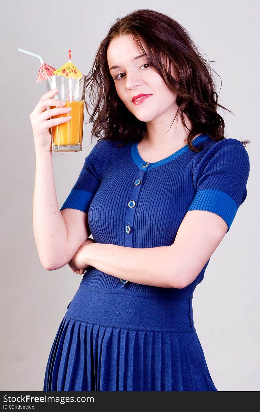 Beauty young woman with orange cocktail in blue dress