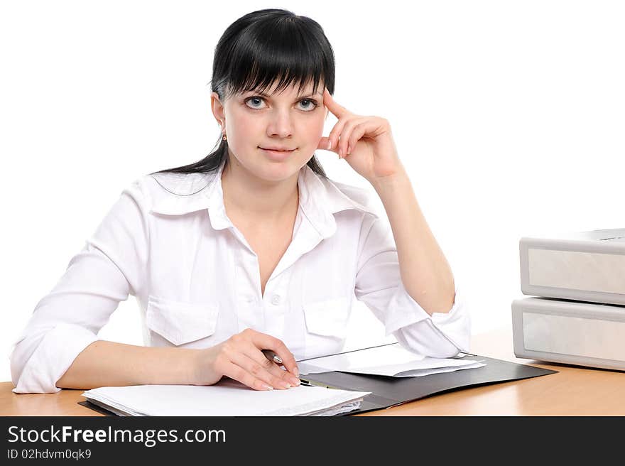 Beautiful young woman in a white shirt sits at a table with the handle in a hand. Beautiful young woman in a white shirt sits at a table with the handle in a hand