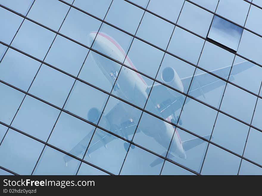 Building with a glass pattern with an airplane reflected