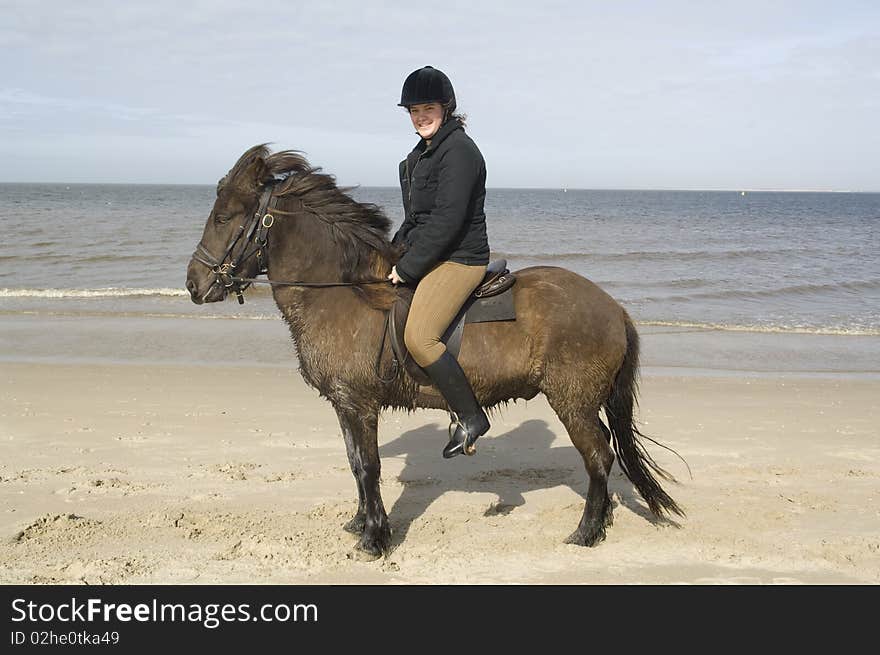 Two amazones on horseback on the beach and in sea