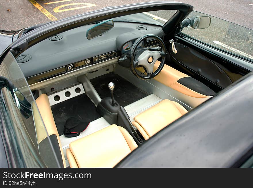 An image of the interior of a classic sports car with the hood down. An image of the interior of a classic sports car with the hood down.