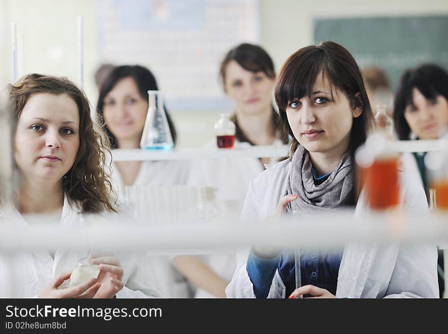 Young woman students group in bright chemistry lab. Young woman students group in bright chemistry lab