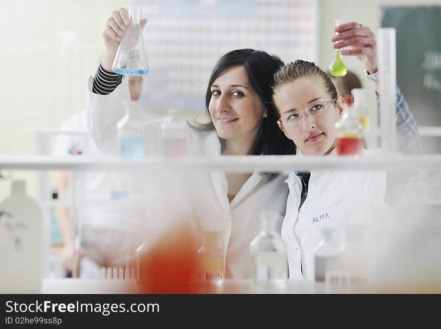 Young woman students group in bright chemistry lab. Young woman students group in bright chemistry lab