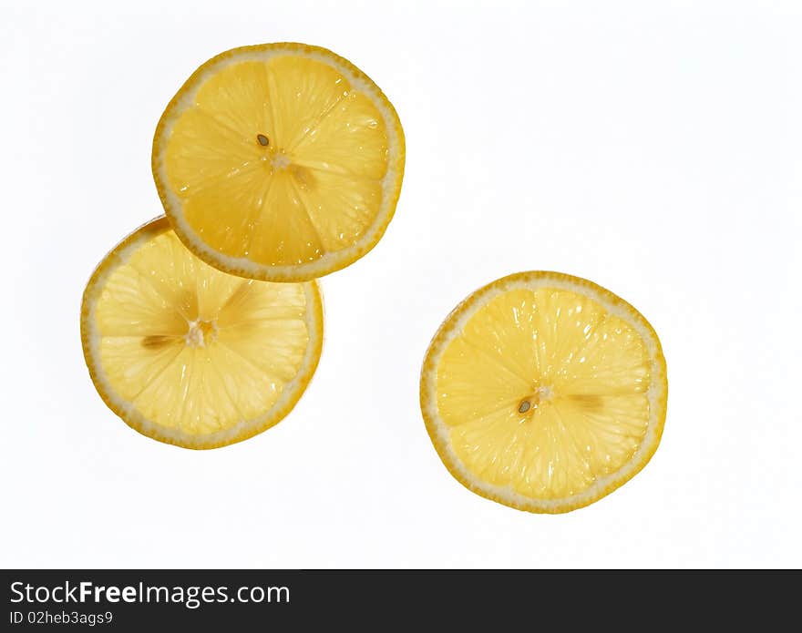 Lemon sliced into wedges on a white background