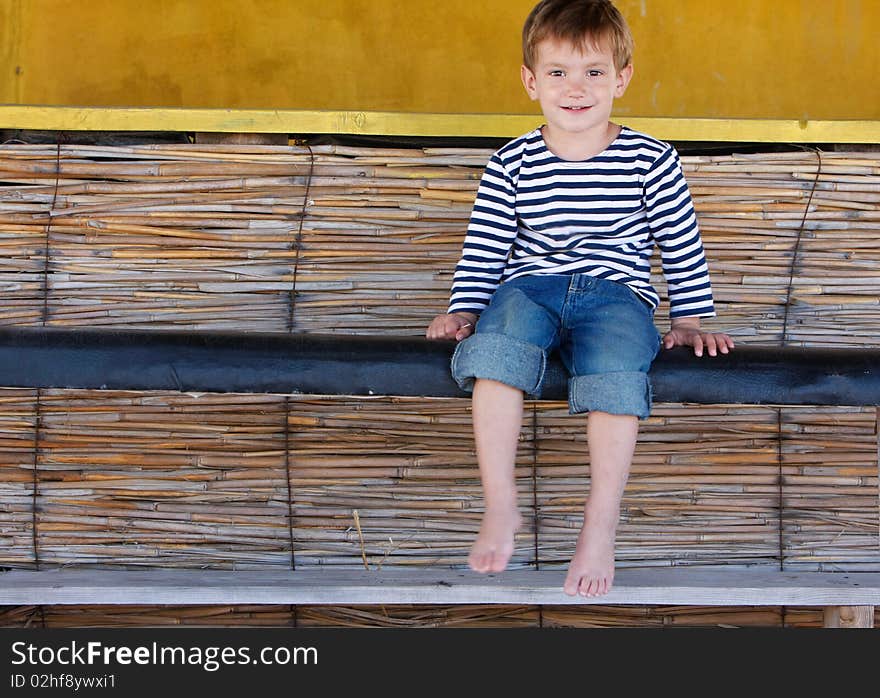 Cute smiling boy sitting in beach bar