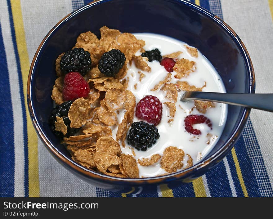 Bowl of cereal with milk and berries on a striped