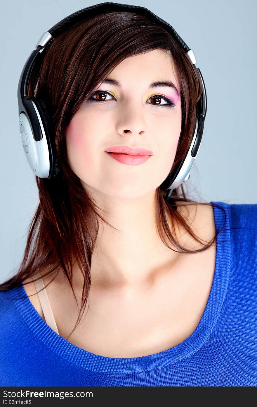 Shot of a pretty young woman in headphones listening to music with pleasure. Shot in a studio. Shot of a pretty young woman in headphones listening to music with pleasure. Shot in a studio.