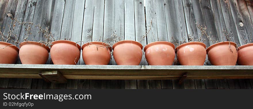 An artistic image of pottery on a wooden shelf.