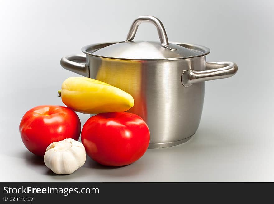 Pepper, garlic, tomato and pan on grey background. Pepper, garlic, tomato and pan on grey background