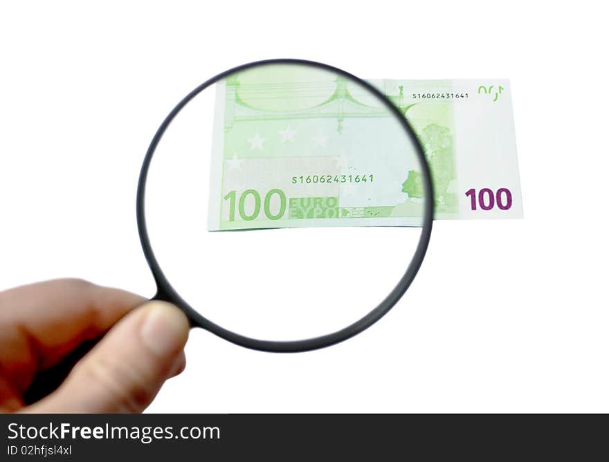 100 euro banknote being inspected under the magnifying glass in the hand. 100 euro banknote being inspected under the magnifying glass in the hand