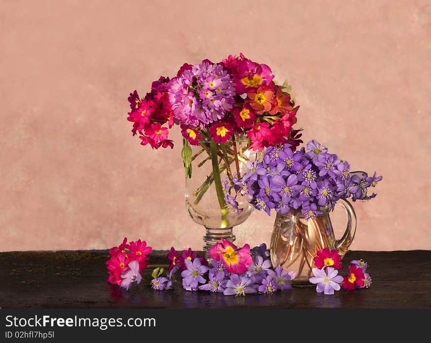 Bouquet of flowers in the spring primroses glass pitcher. Bouquet of flowers in the spring primroses glass pitcher