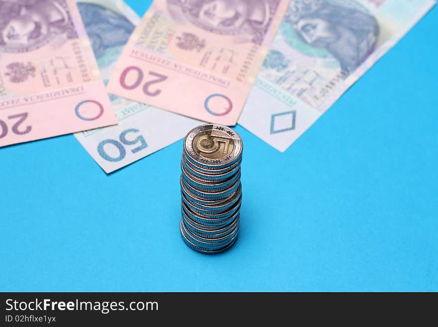 Stack of Polish coins and Paper in background. Blue background. Stack of Polish coins and Paper in background. Blue background