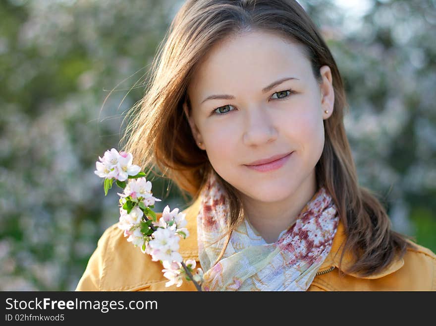 Young woman posing with a blooming branch in a spring park. Young woman posing with a blooming branch in a spring park