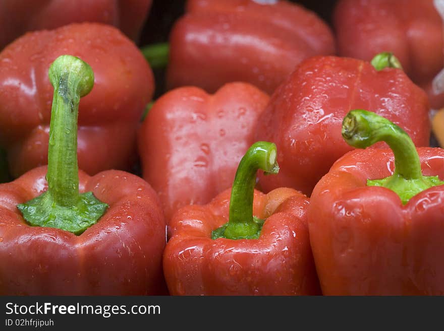 Bright red bell peppers with green stems. Bright red bell peppers with green stems.