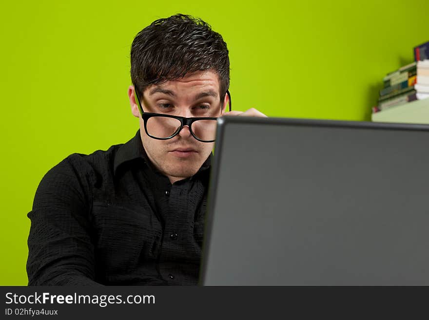 Young man squinting at the laptop. Young man squinting at the laptop