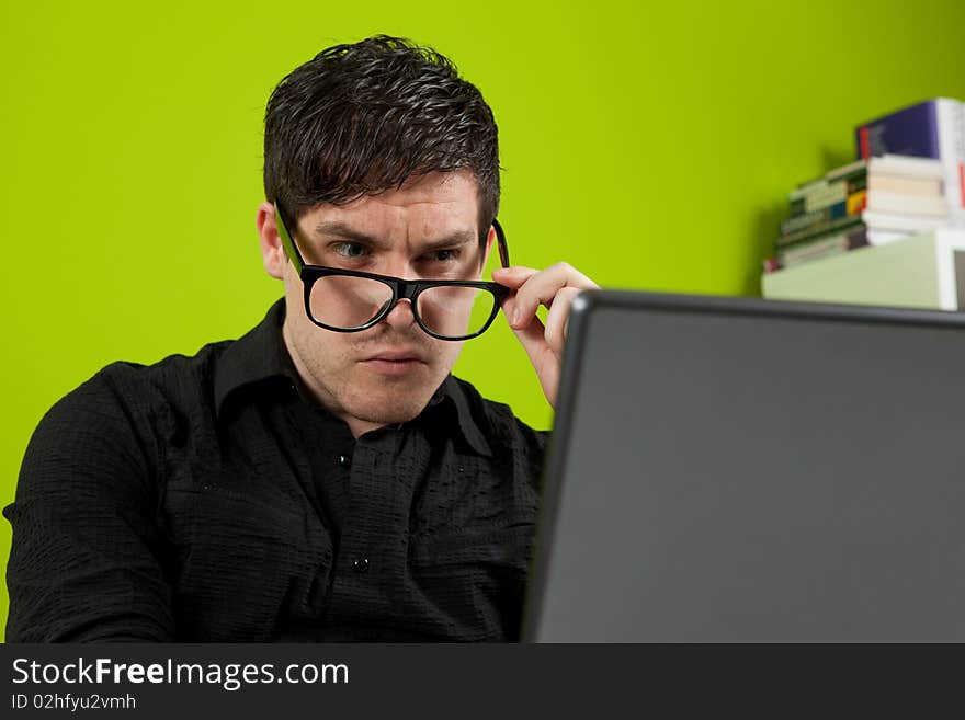 Young man squinting at the laptop. Young man squinting at the laptop