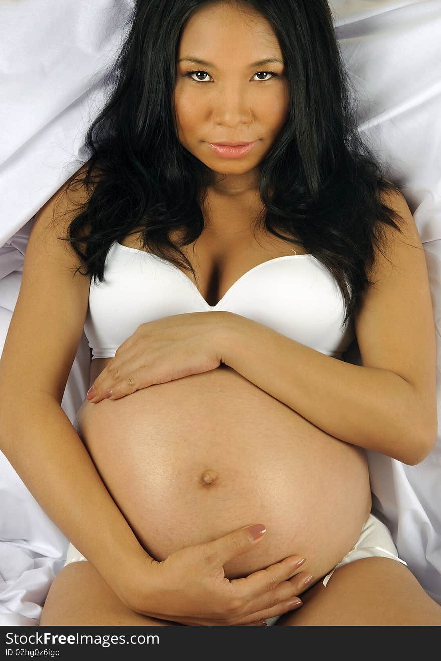 Beautiful pregnant woman holds her tummy on the bed. Beautiful pregnant woman holds her tummy on the bed