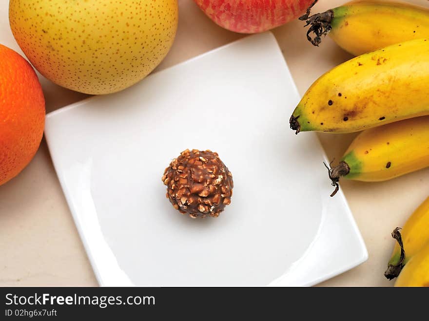 Contrast of fruits and unhealthy sweets to signify concepts such as healthy lifestyle, diet and nutrition, and food and beverage.