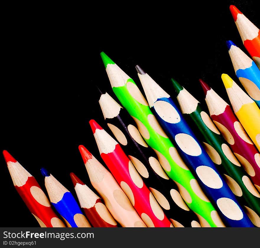 Colored crayons over black backround, indoor shoot