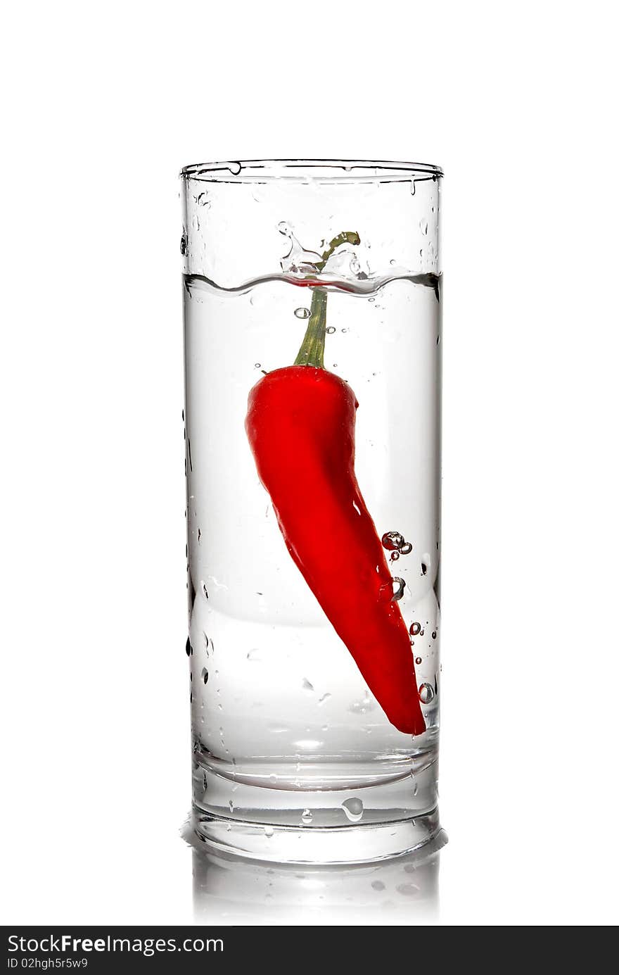 Red pepper dropped into water glass