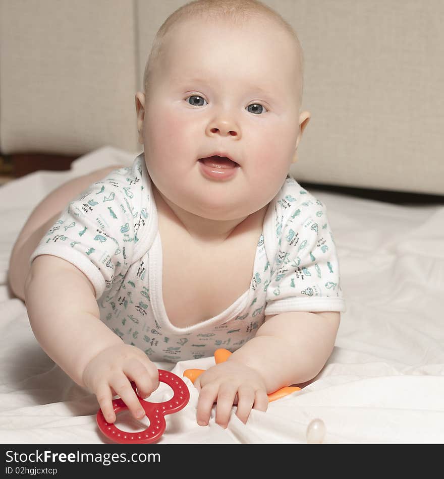 Baby girl (7 months) playing with plastic toys at home