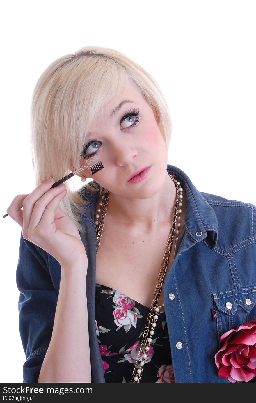 Photograph of pretty blond girl putting on make up isolated against white