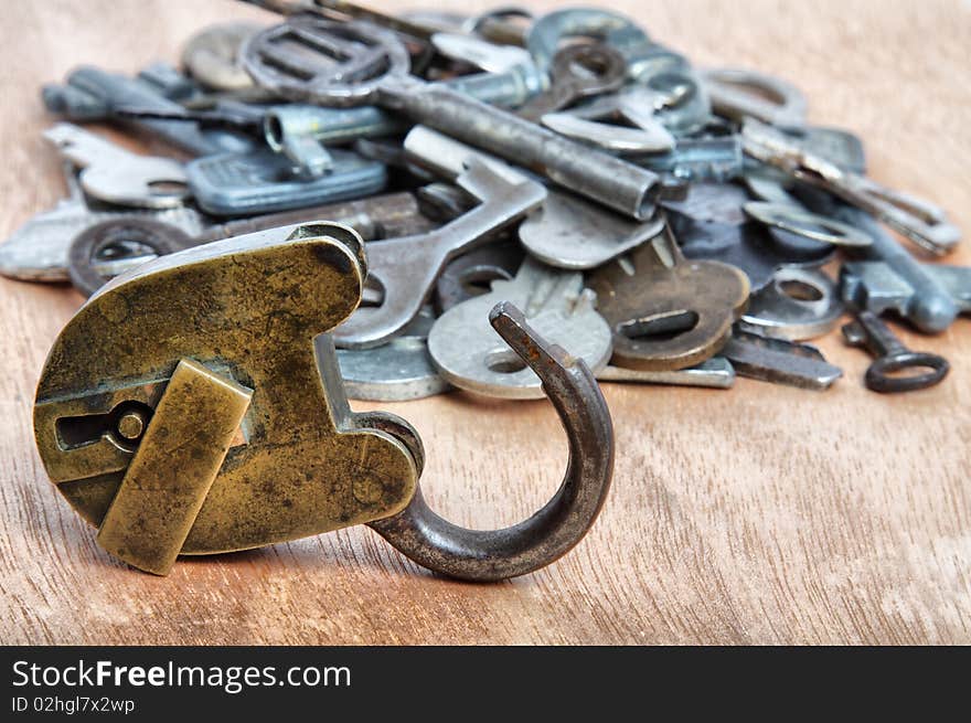 Old padlock and heap keys on wood