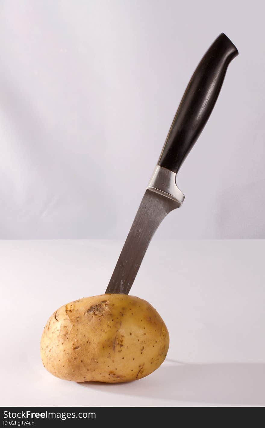 Knife in potato on the table