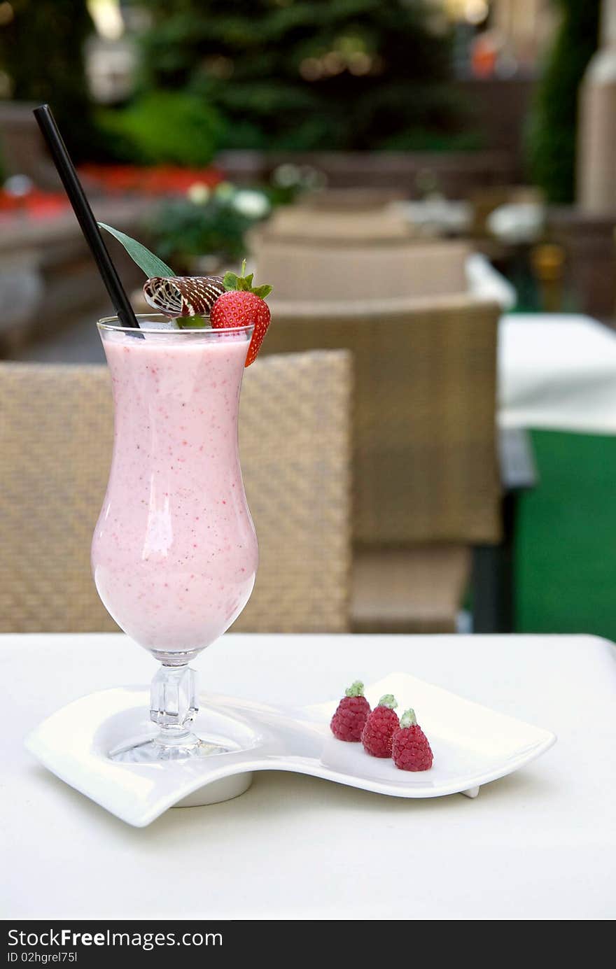 Strawberry milkshake in the glass on the table. Strawberry milkshake in the glass on the table