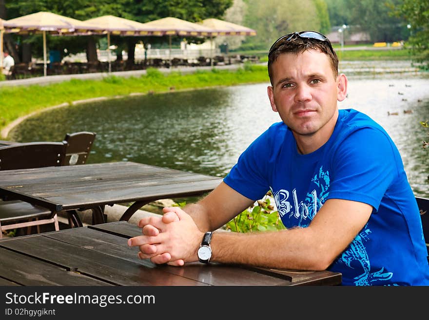 The young man sits in cafe at a table