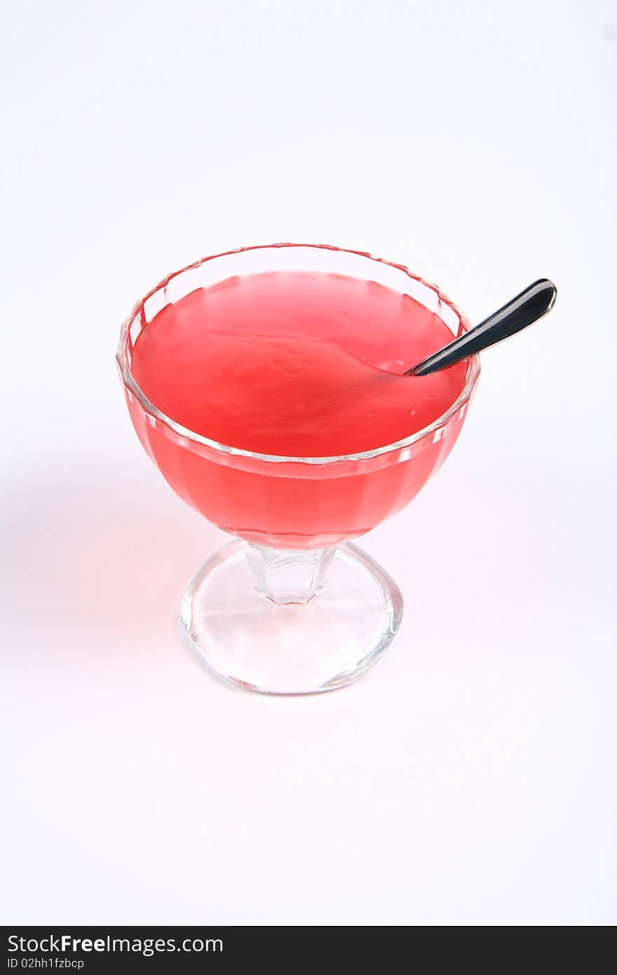 Strawberry fruit cream in a glass cup with a spoon