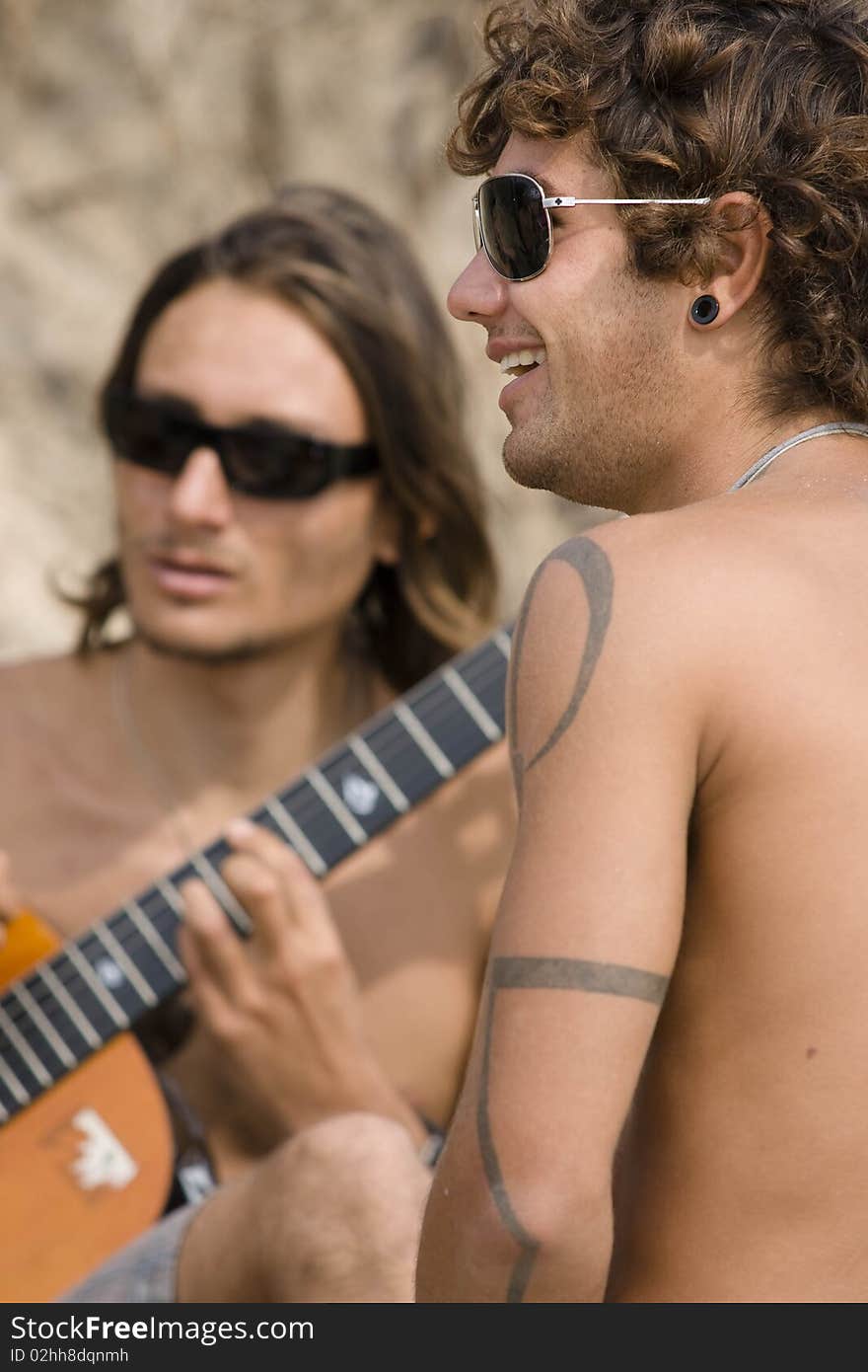 The two young guitarists playing on seacoast. The two young guitarists playing on seacoast