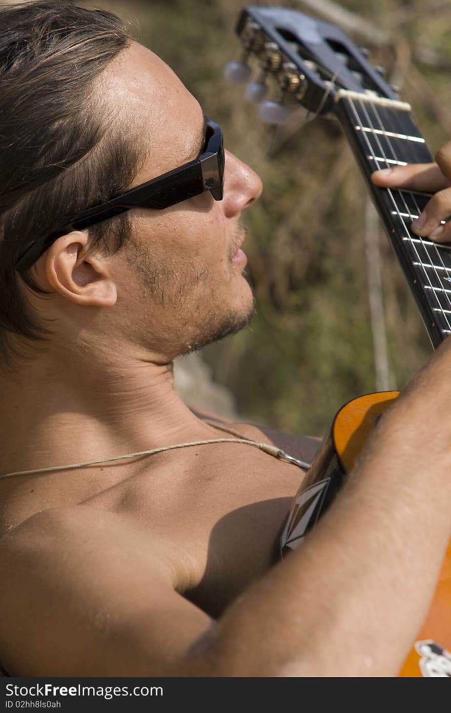 Young man playing the guitar on the beach. Young man playing the guitar on the beach