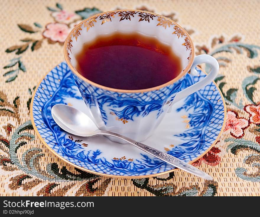 Cup with tea on a saucer and a silver teaspoon