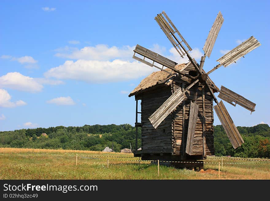 An old windmill standing in a field, summer