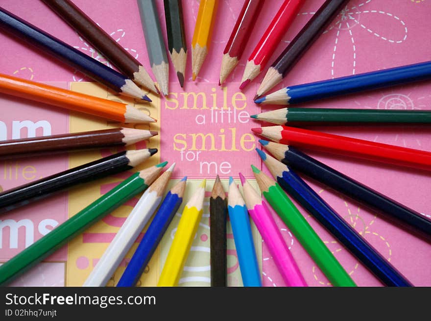 Color pencils on pink background with the inscription