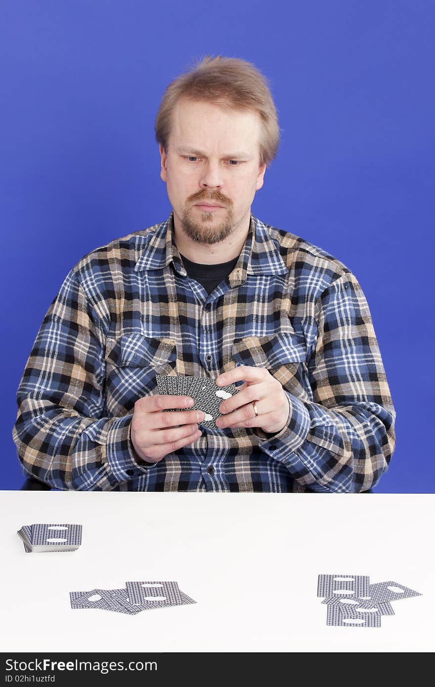 Man mixes cards when playing solitaire/patience.