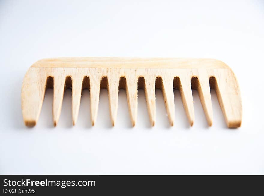 An ethnic wooden comb on a white background. An ethnic wooden comb on a white background.