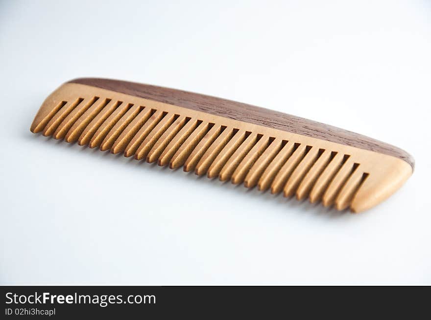 An ethnic wooden comb on a white background. An ethnic wooden comb on a white background.