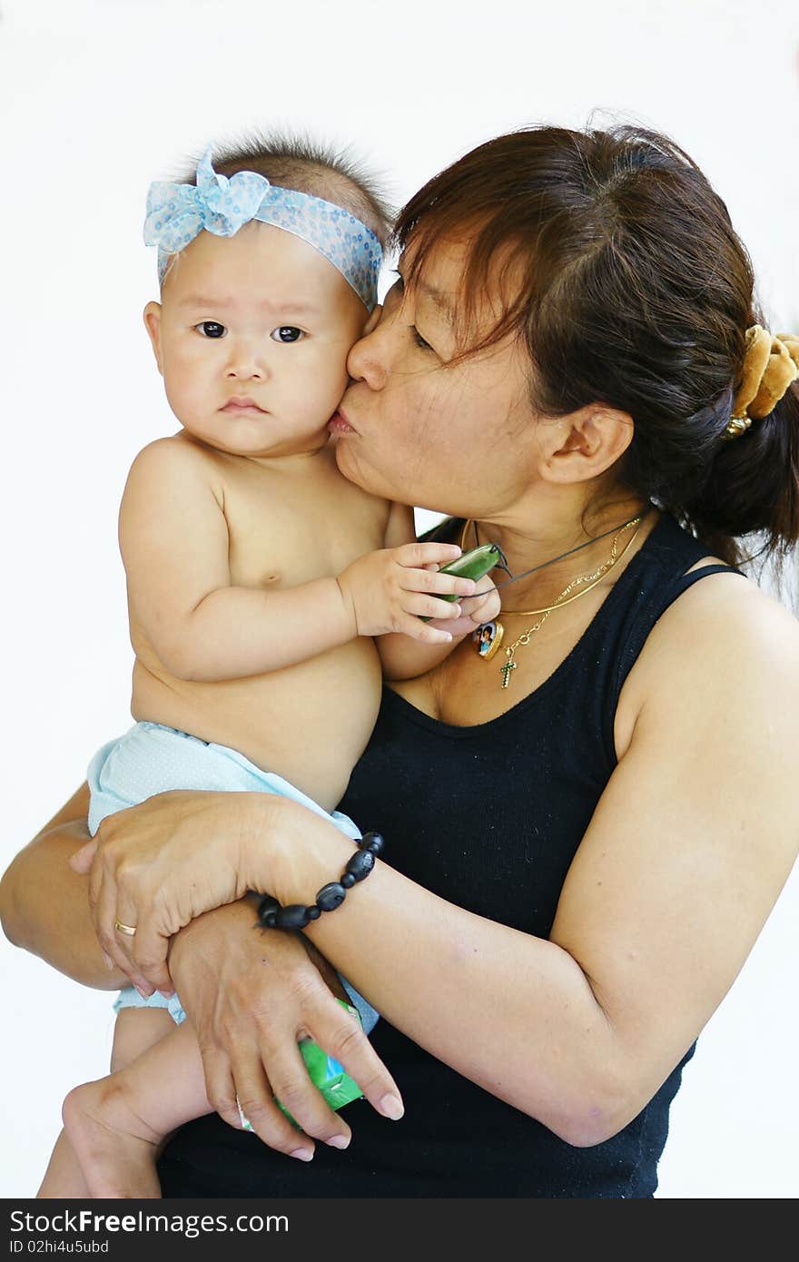 Mother holding baby kissing cheek. Mother holding baby kissing cheek