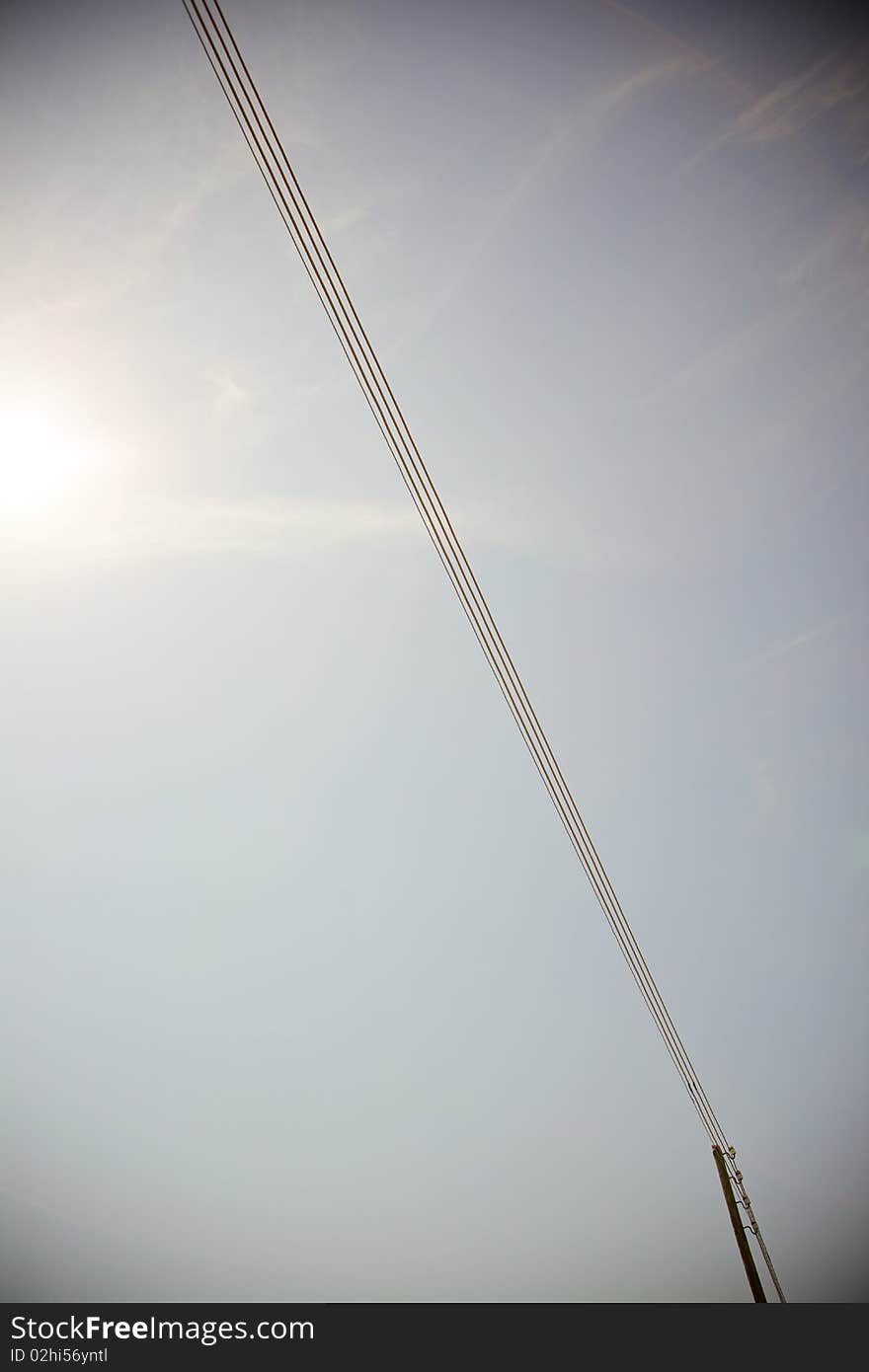 A power line on a blue sky background. A power line on a blue sky background