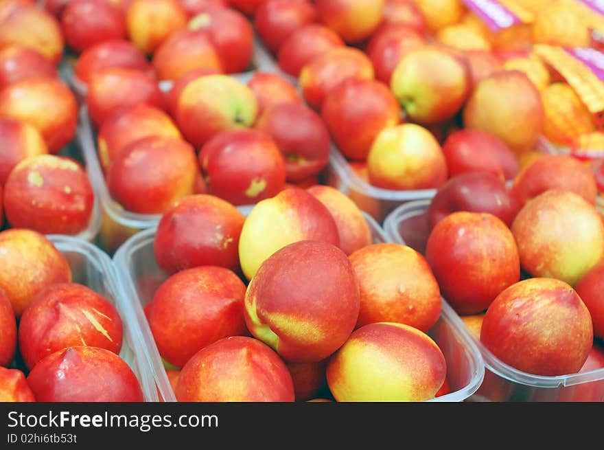 Close up of red nectarines on market stand