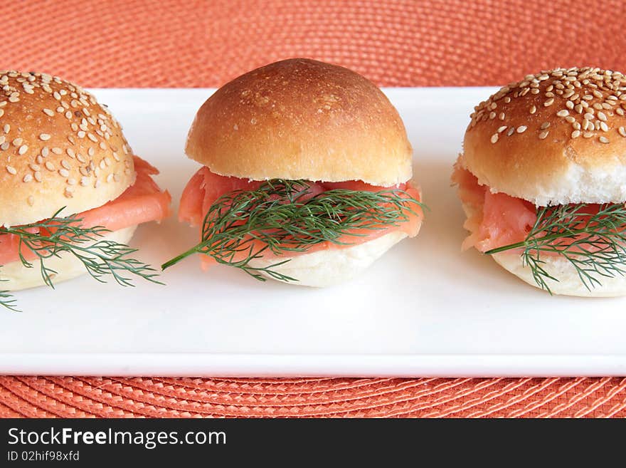 Smoked salmon party buns on a white rectangular plate. Smoked salmon party buns on a white rectangular plate