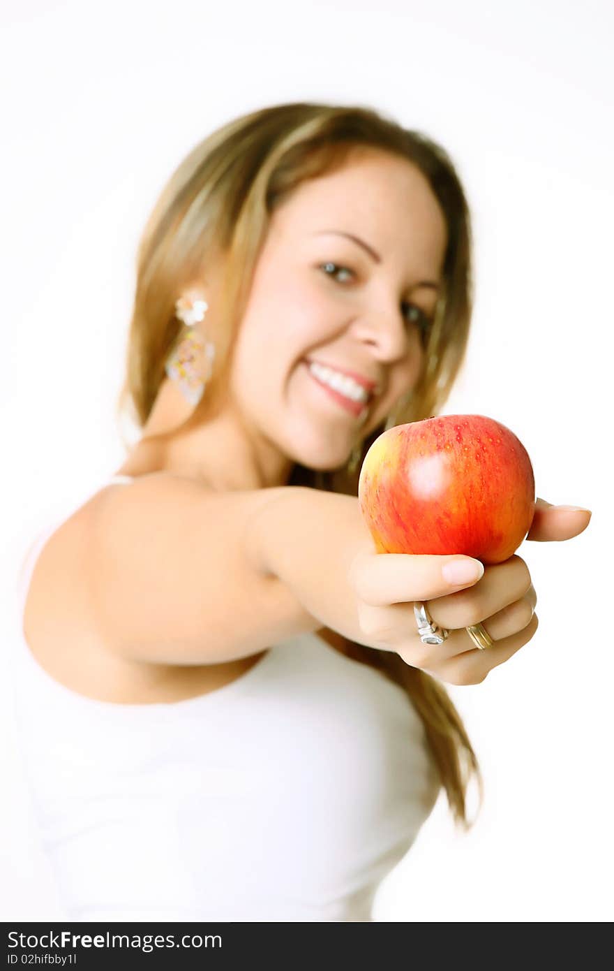 Woman showing an apple and smiling, white background, selective focus. Woman showing an apple and smiling, white background, selective focus