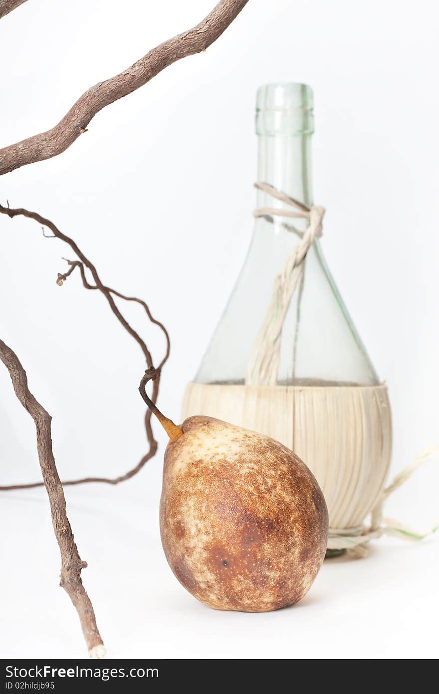 Pear on the branch & bottle on a white